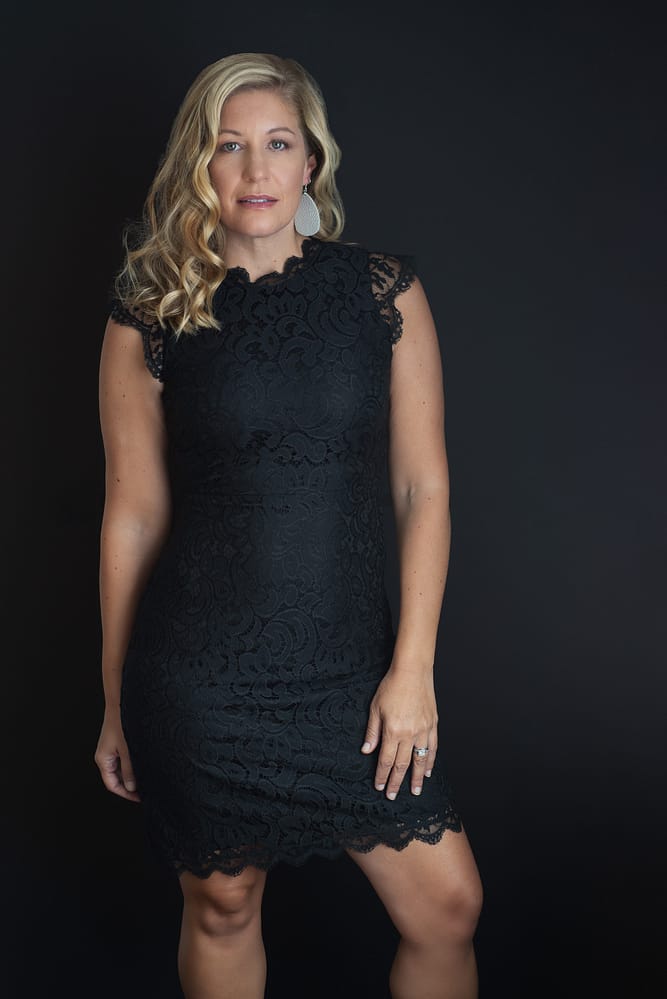Blonde woman standing in black dress with black background blonde-woman-standing-black-dress-Amy Paris Photography-Highland IN
